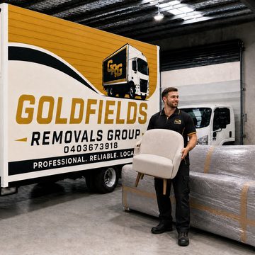 Goldfields Removals Group crew member delivering a chair beside the branded truck